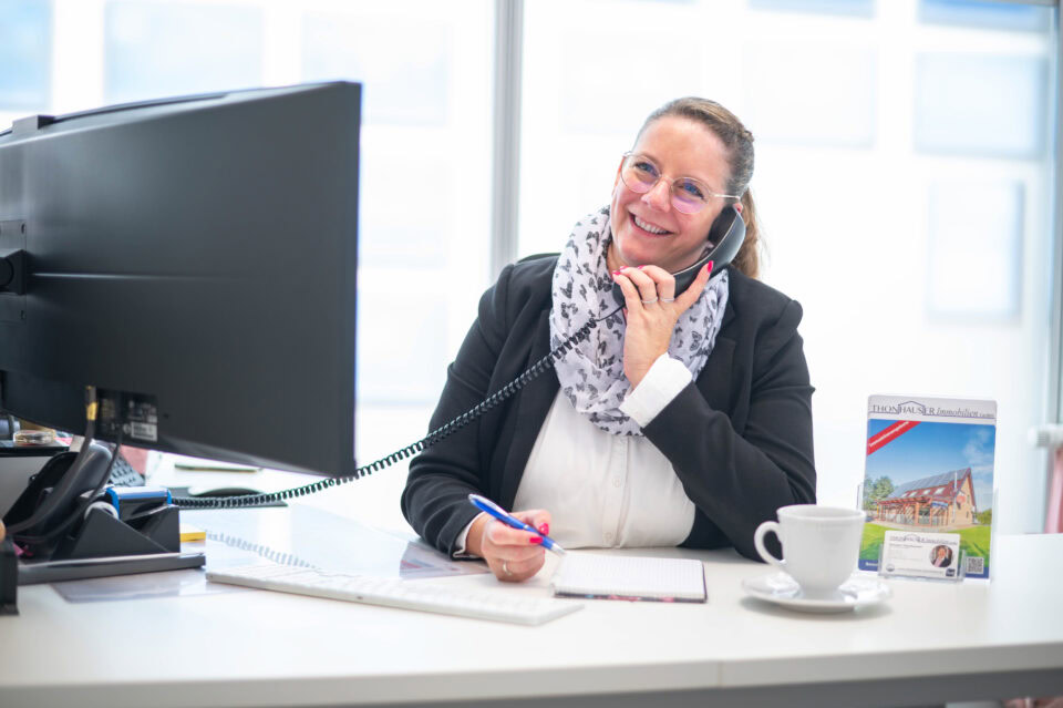 Händlerin im Büro bei Thonhauser Immobilien, Kundenberatung, Immobilienservice.