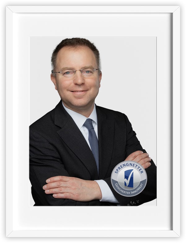 Attraktiver Immobilienmakler in professionellem Anzug, vertrauenswürdig und kompetent.